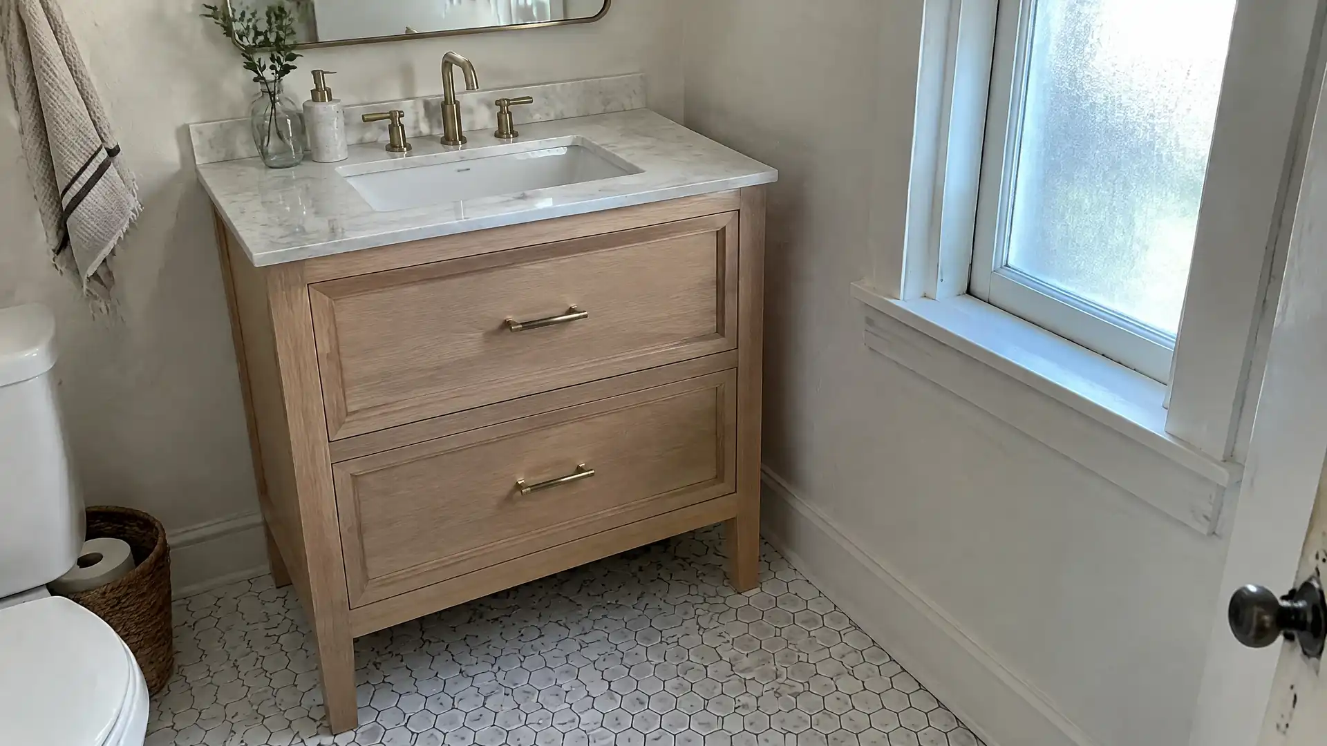 A white oak bathroom vanity with inset drawers under a stone top in an older Lynn home