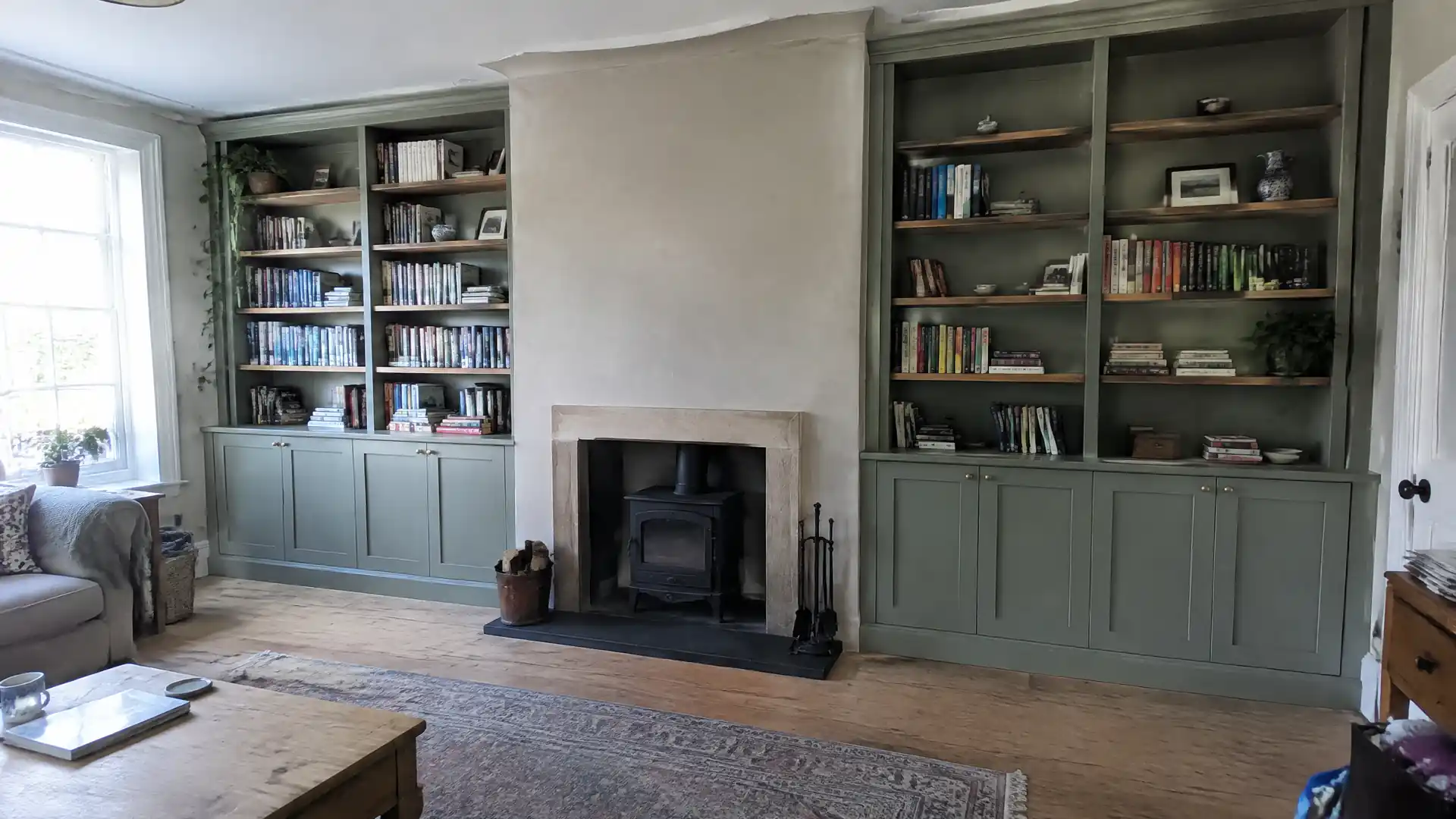 Floor-to-ceiling painted bookcases flanking a chimney breast with crown scribed to a wavy ceiling
