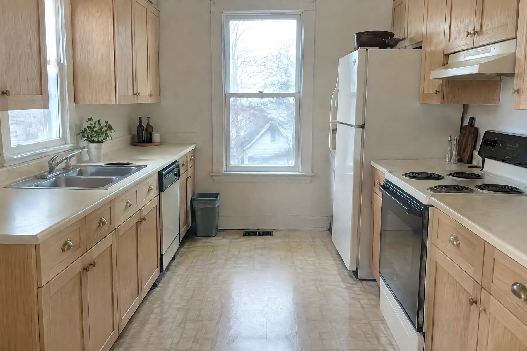 The same kitchen after refacing with light oak doors and drawer fronts and brass knobs