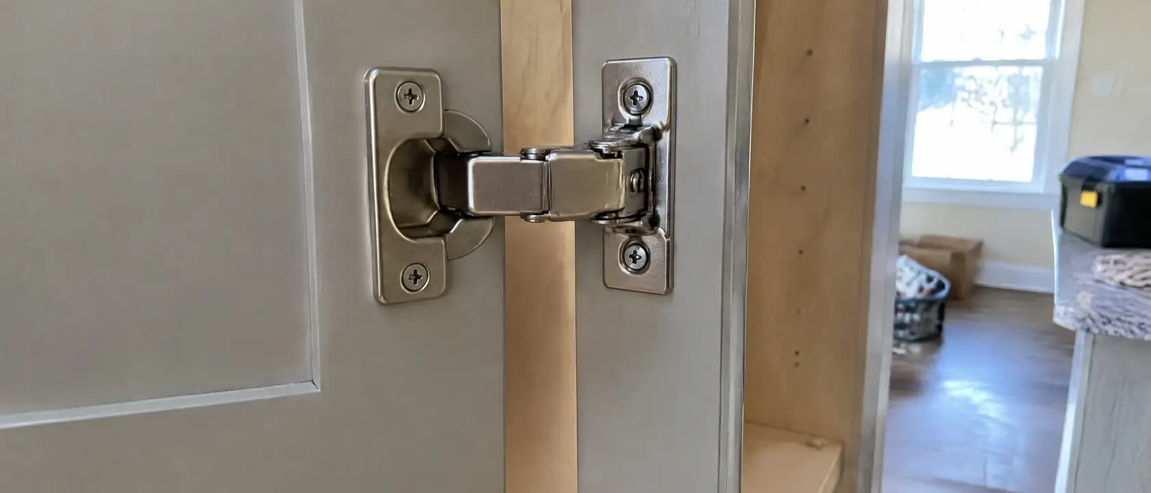A concealed soft-close hinge seated in a cabinet door bore with the mounting plate alongside