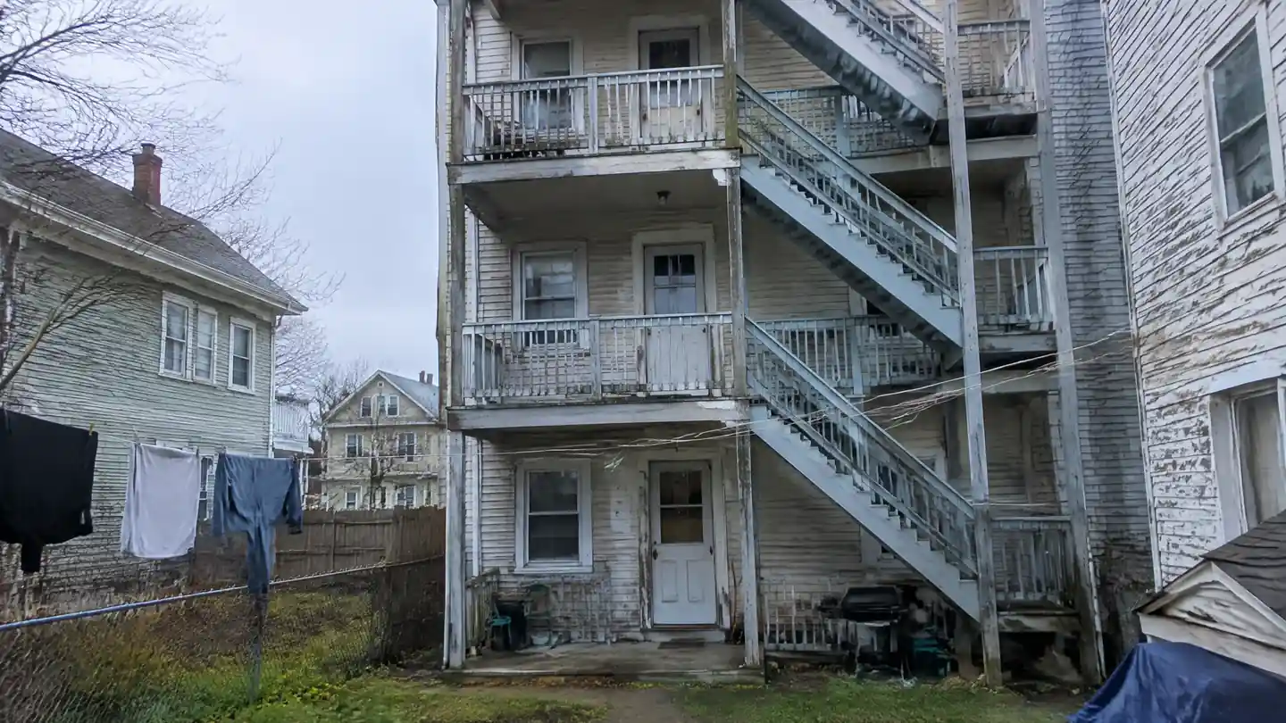 The rear porch stack of a three-story wooden multi-family house