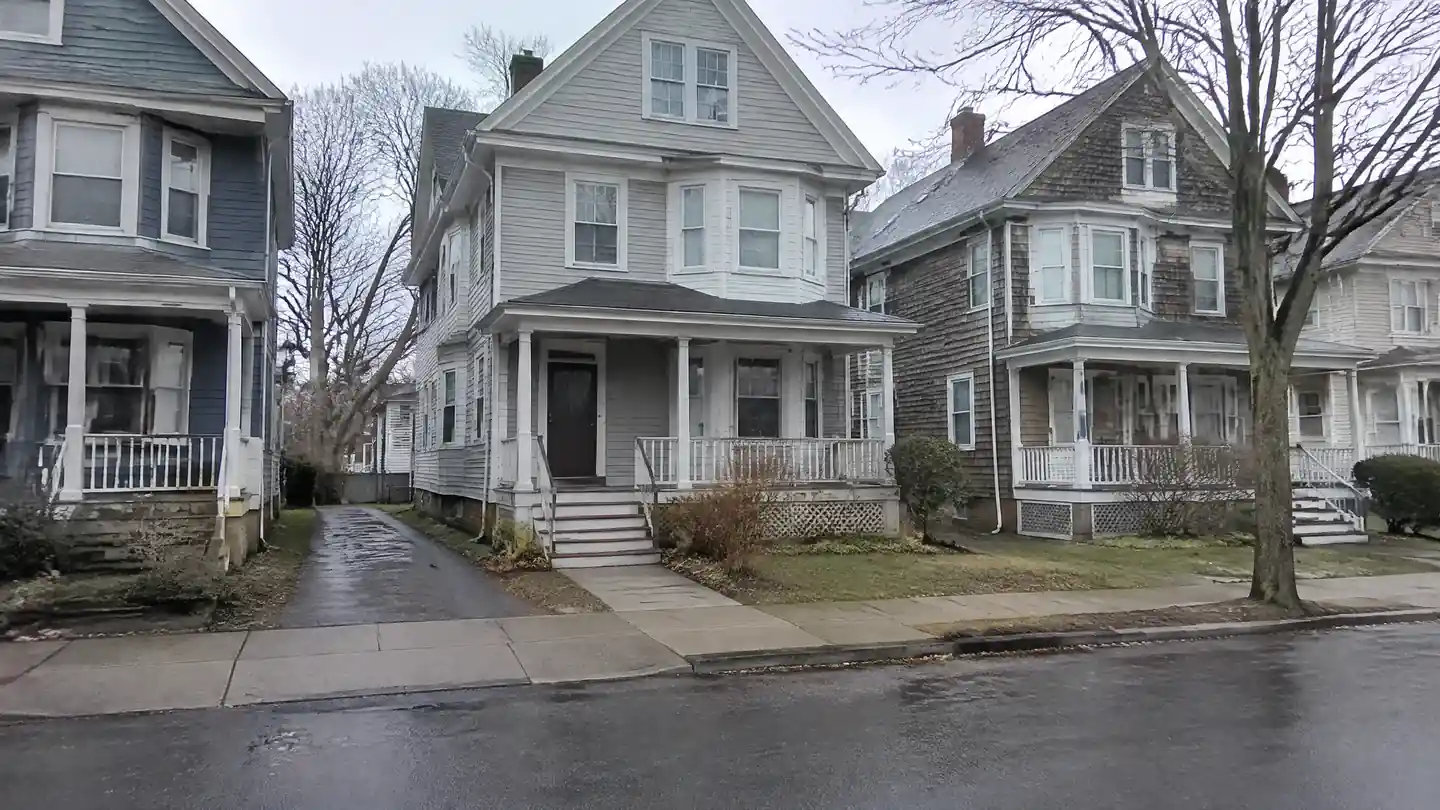 A street of closely spaced early-1900s wooden houses with porches and bay windows