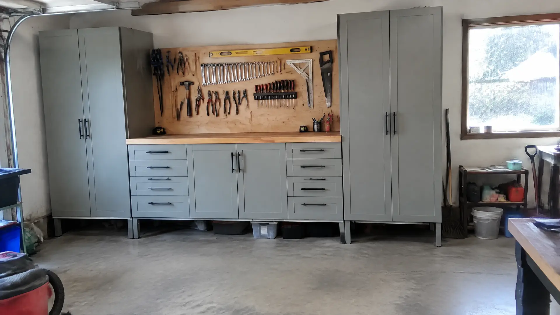 Tall painted garage storage cabinets and a work counter raised clear of a damp concrete floor