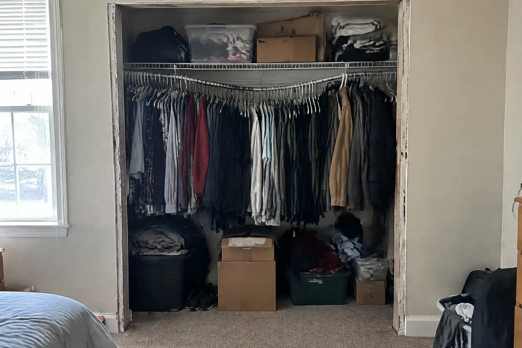 A shallow bedroom reach-in closet with a sagging rail and one wire shelf before fitting out