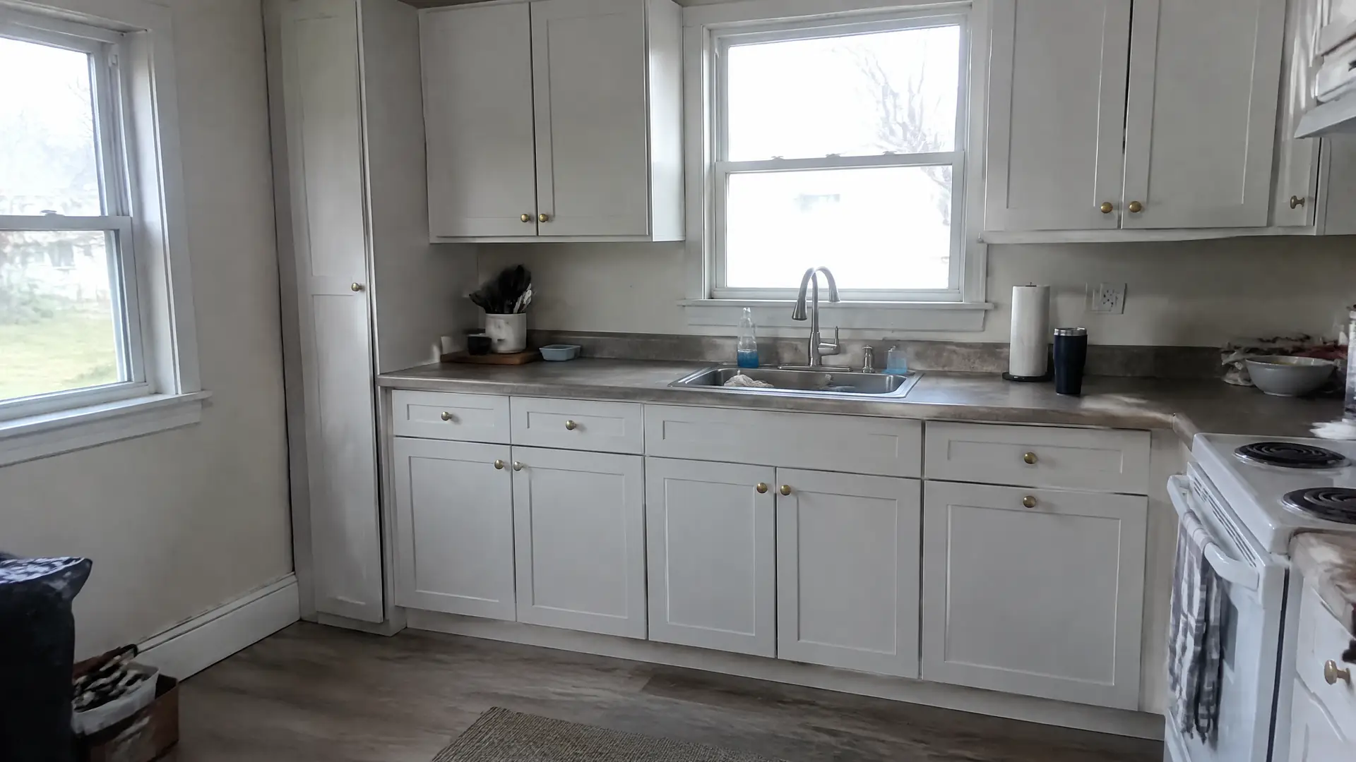 A plain painted shaker kitchen with a deeper filler panel where the old wall runs out of square